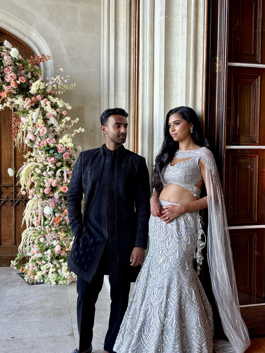 Wedding couple by a floral arch